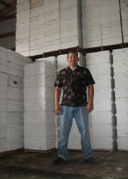 Beekeeper Stan Kolesnikov in front of a few of his stored honey supers